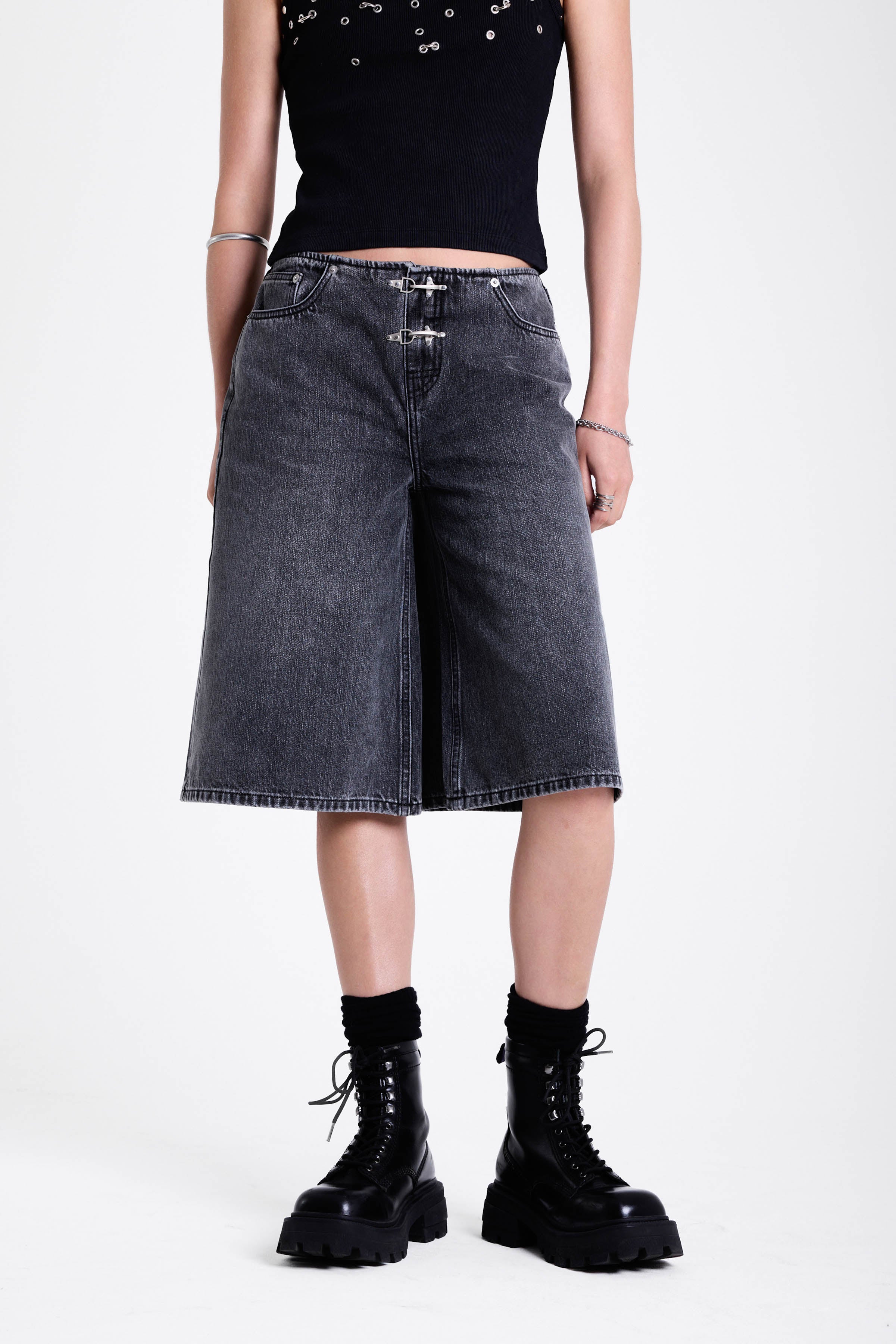 Washed black longline oversized denim jorts with no waistband and silver latch clasp detail, worn by model