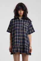 Navy and yellow check mini dress with button fastening, collar and peplum hem, worn by model