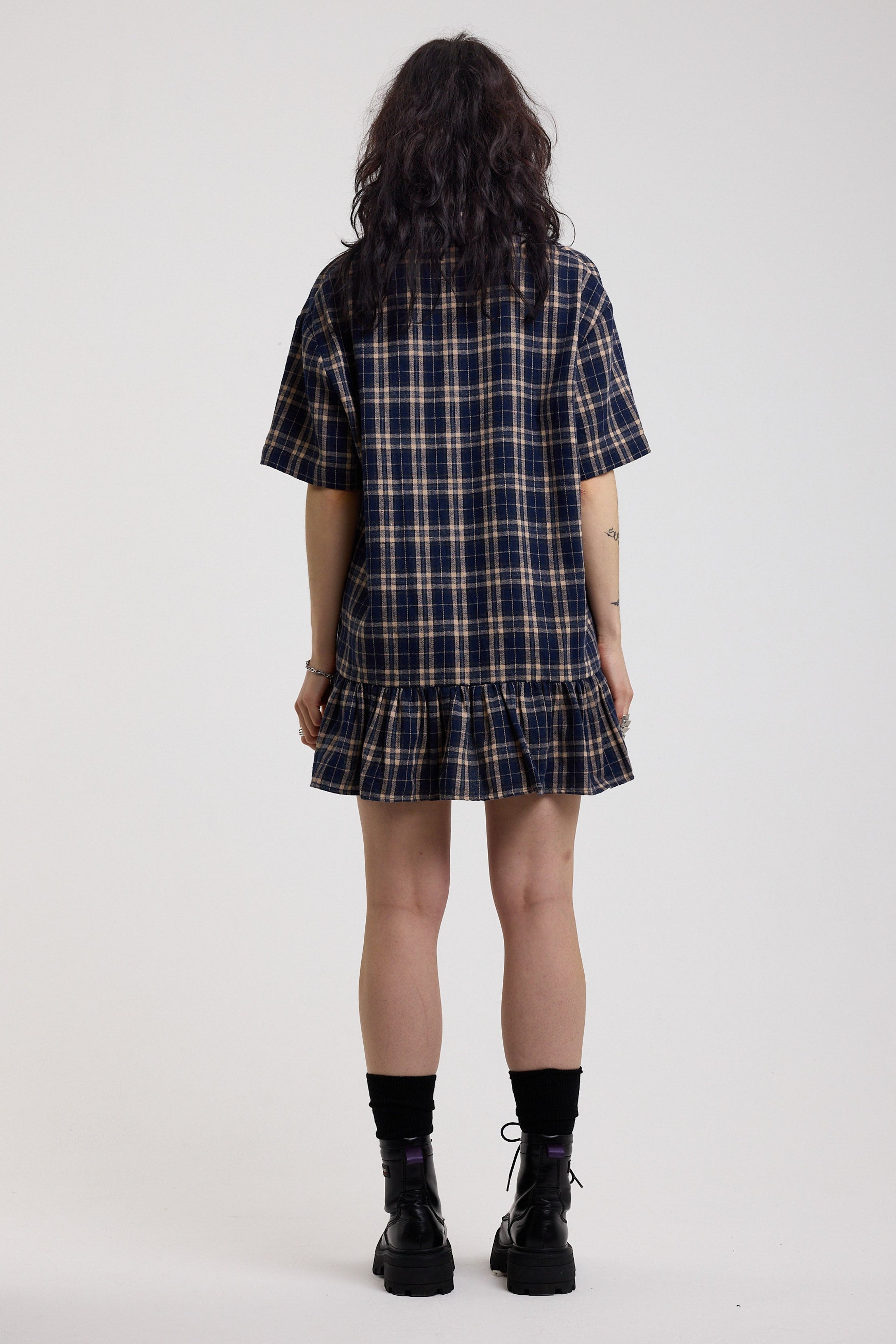 Back image of navy and yellow check shirt style mini dress with peplum hem, worn by model