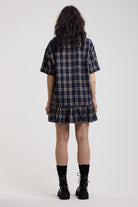 Back image of navy and yellow check shirt style mini dress with peplum hem, worn by model