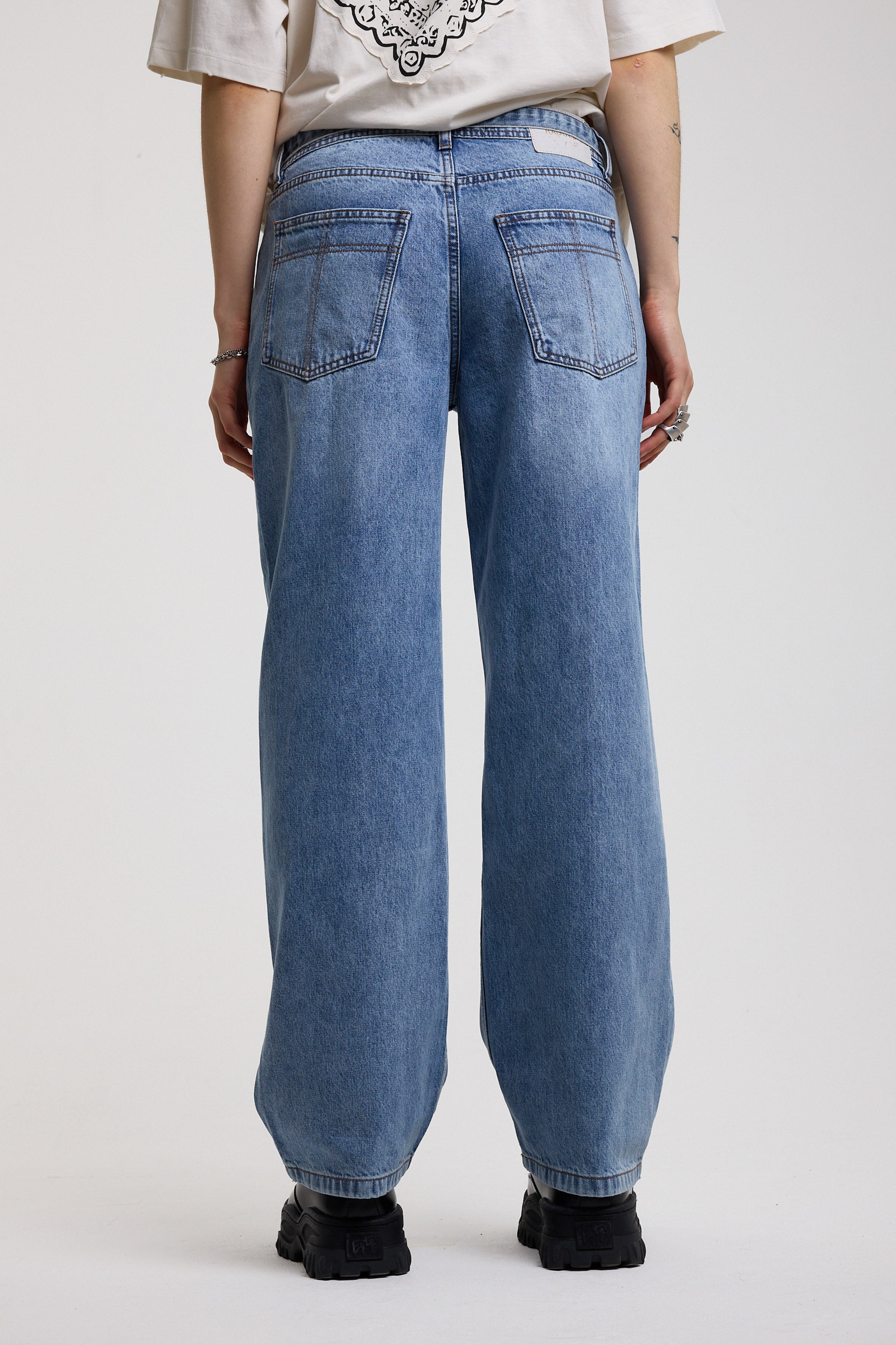 Back of blue baggy balloon boyfriend jeans with denim tie belt, worn by model
