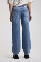 Back of blue baggy balloon boyfriend jeans with denim tie belt, worn by model