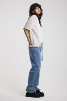 Side of blue baggy balloon boyfriend jeans with denim tie belt, worn by model