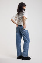 Back image of blue baggy balloon boyfriend jeans with denim tie belt, worn by model
