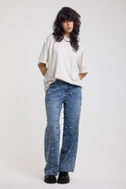 Blue baggy release jeans with silver stud detail, worn by model 