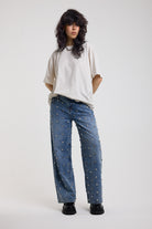 Blue baggy release jeans with silver stud detail, worn by model 