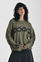 Washed khaki oversized knit jumper with black barbed wire tattoo graphic, worn by model