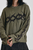 Washed khaki oversized knit jumper with black barbed wire tattoo graphic, worn by model