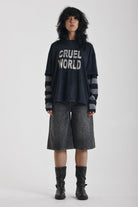 Washed black long sleeve skate t-shirt with CRUEL WORLD graphic print and contrast stripe sleeves, worn by model