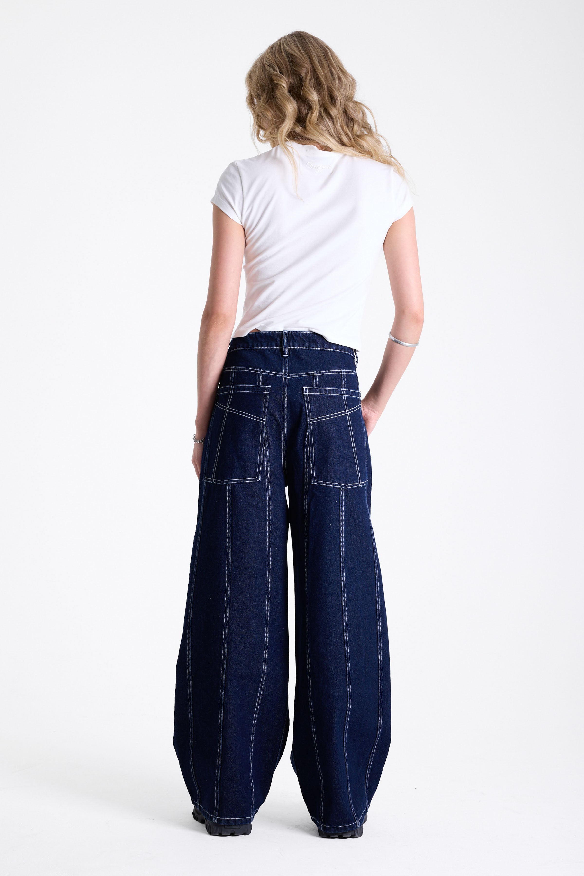 Dark rinse denim baggy wide leg jeans with contrast seam detail, worn by model.