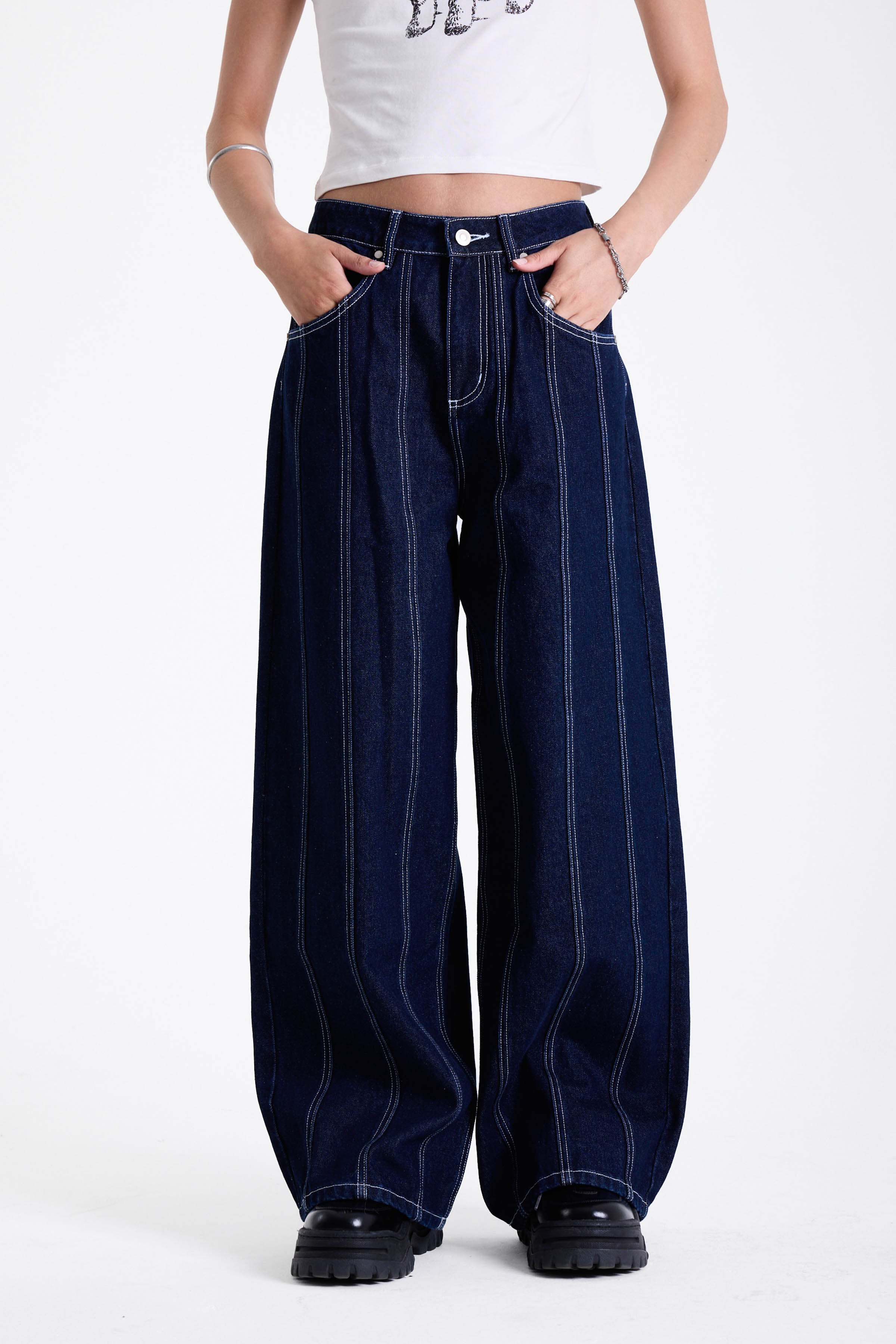 Dark rinse denim baggy wide leg jeans with contrast seam detail, worn by model.