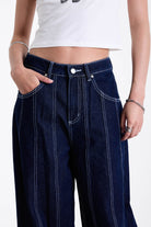 Dark rinse denim baggy wide leg jeans with contrast seam detail, worn by model.