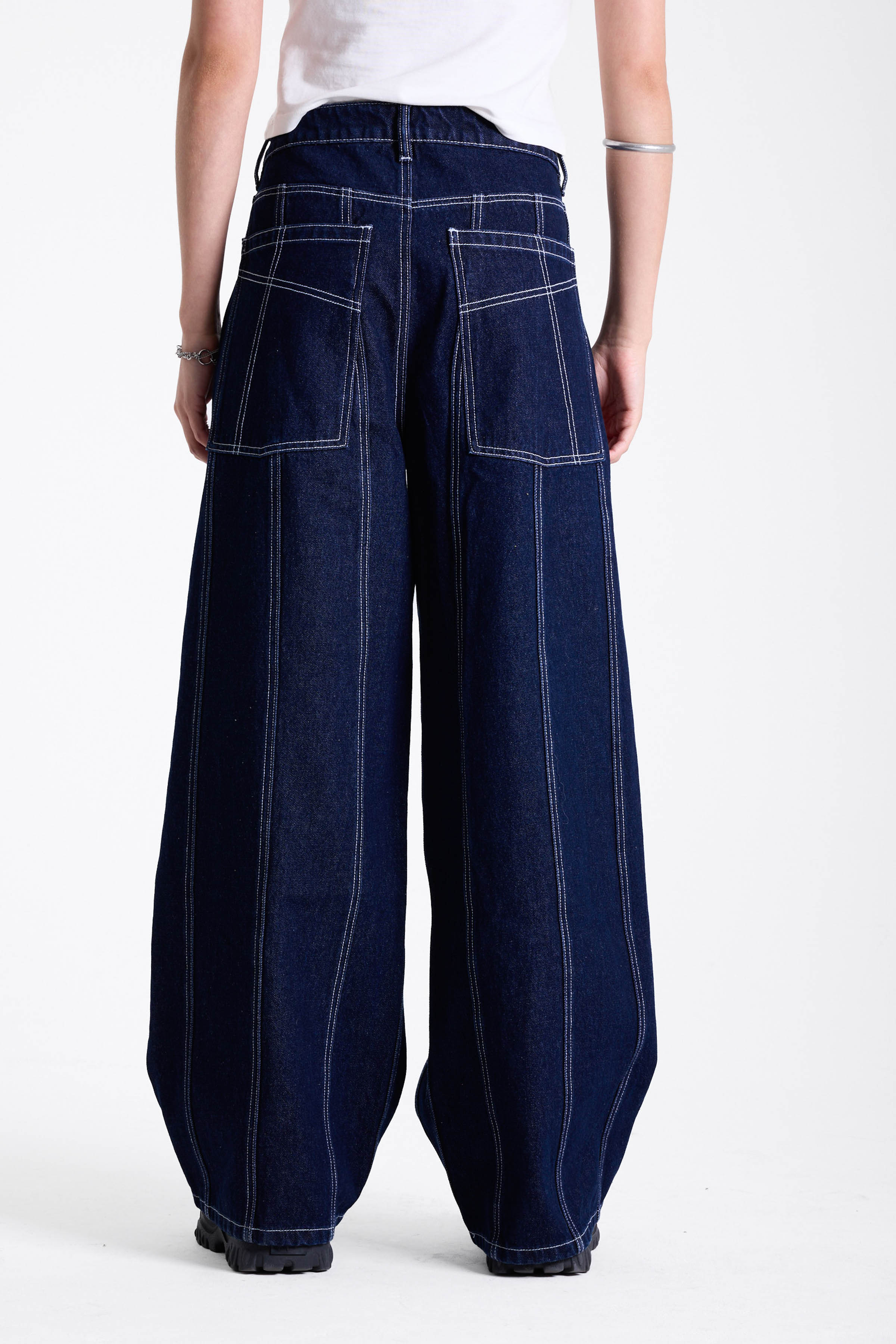 Dark rinse denim baggy wide leg jeans with contrast seam detail, worn by model.