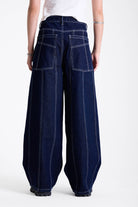 Dark rinse denim baggy wide leg jeans with contrast seam detail, worn by model.