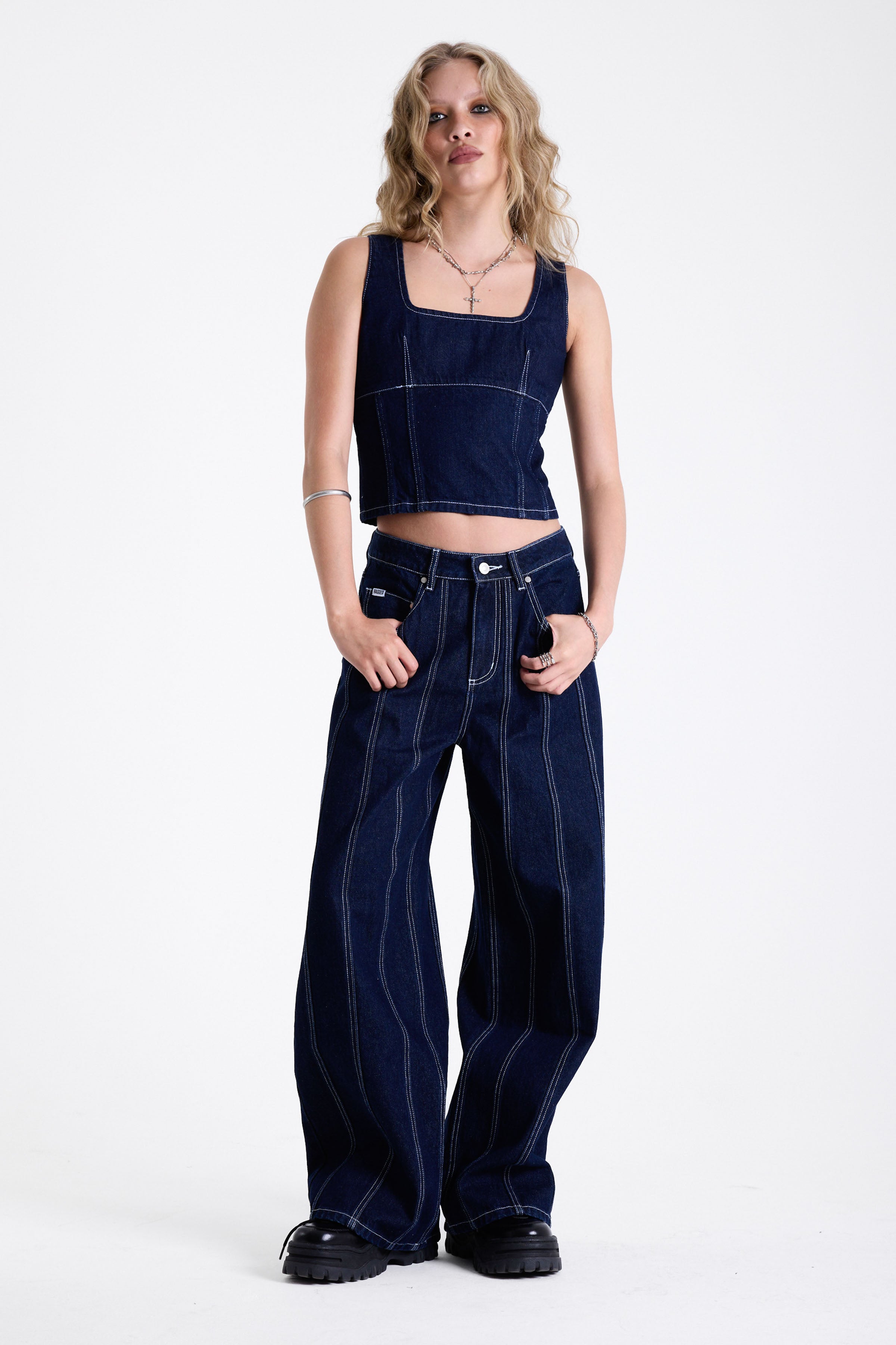 Dark rinse denim baggy wide leg jeans with contrast seam detail, worn by model.