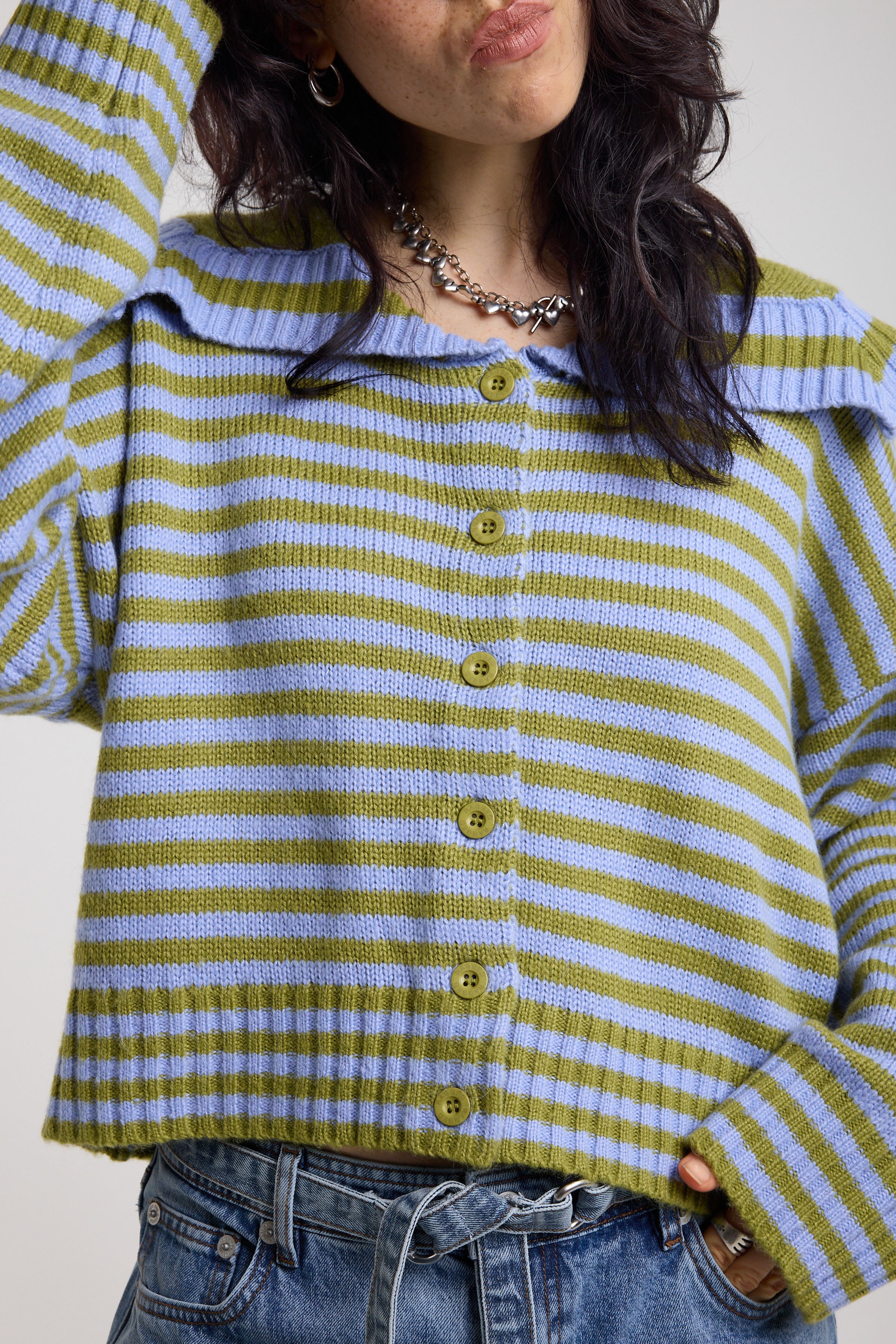 Close up of blue and green stripe knit cardigan with oversized collar, worn by a model