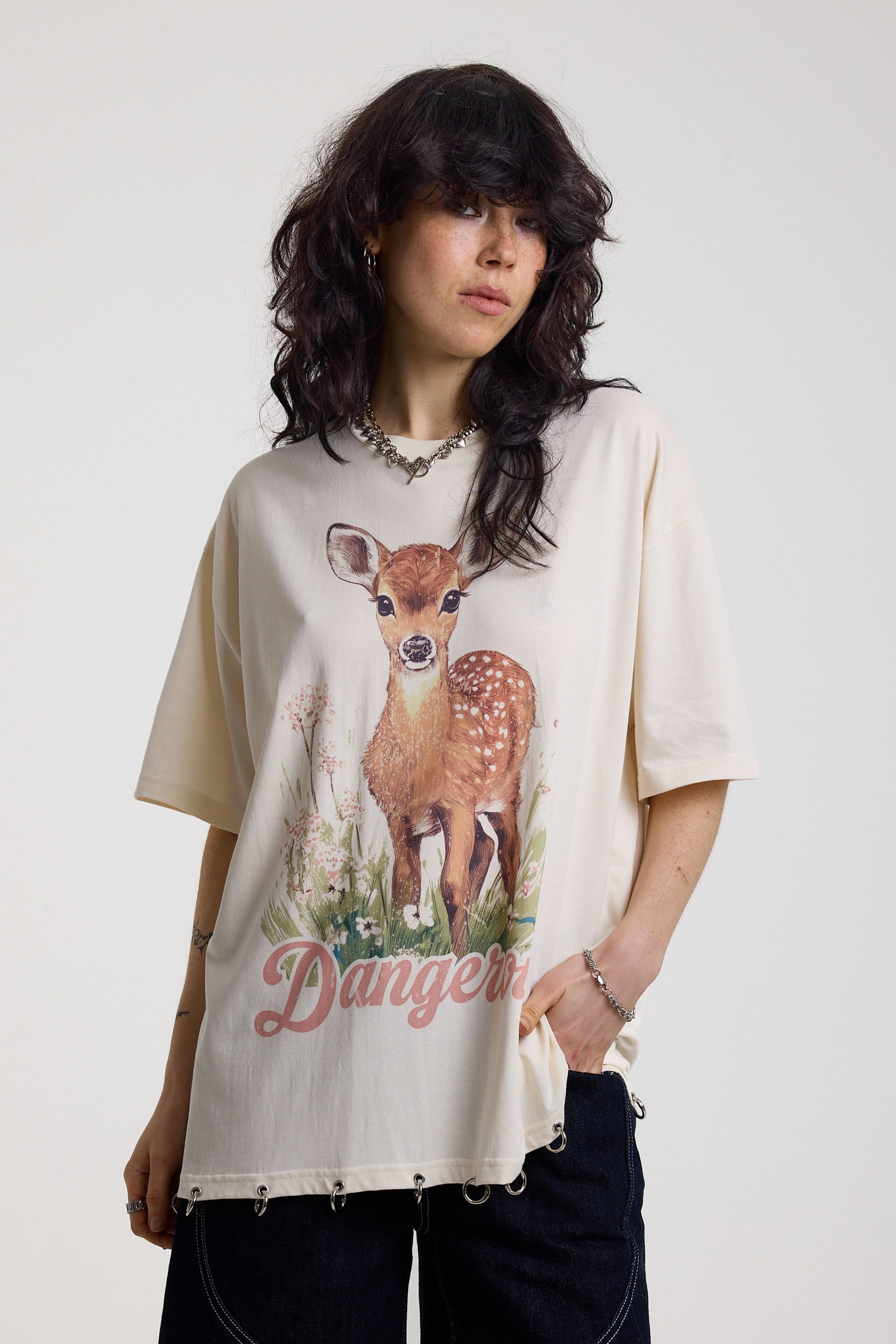 Off-white oversized t-shirt with graphic deer print and silver O-ring hardware detail, worn by model