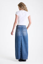 Vintage wash denim maxi skirt with thigh high split and buckle belt fastening, worn by model.