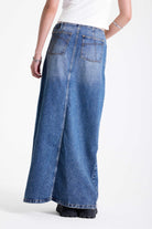 Vintage wash denim maxi skirt with thigh high split and buckle belt fastening, worn by model.