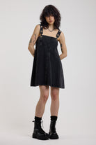 Washed black denim square neck mini dress with eyelet detail straps, worn by model