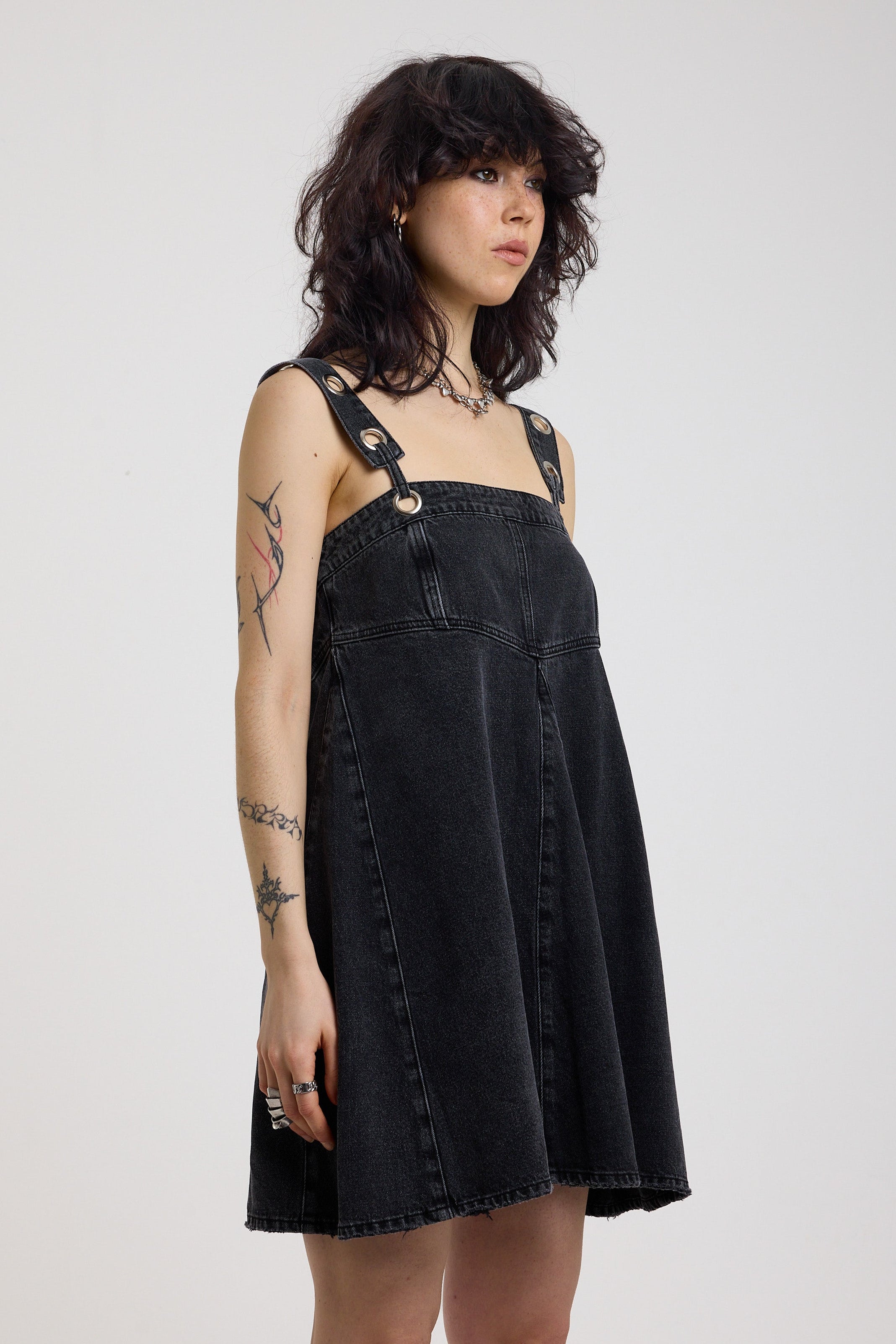 Washed black denim square neck mini dress with eyelet detail straps, worn by model