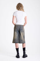 Dirty wash longline oversized denim jorts with no waistband and silver latch clasp detail, worn by model