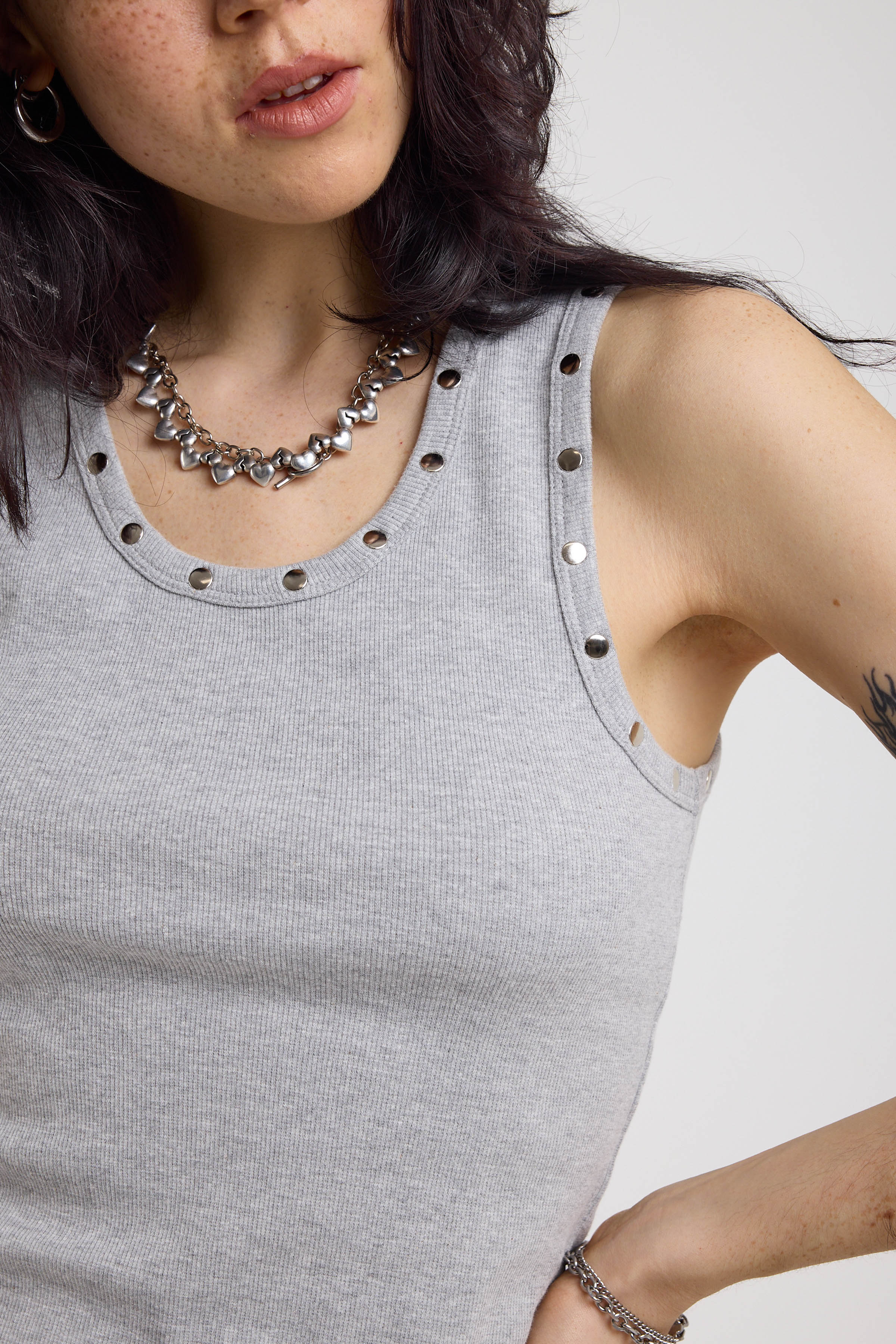 Close up of silver stud detail on grey mini dress, worn by model
