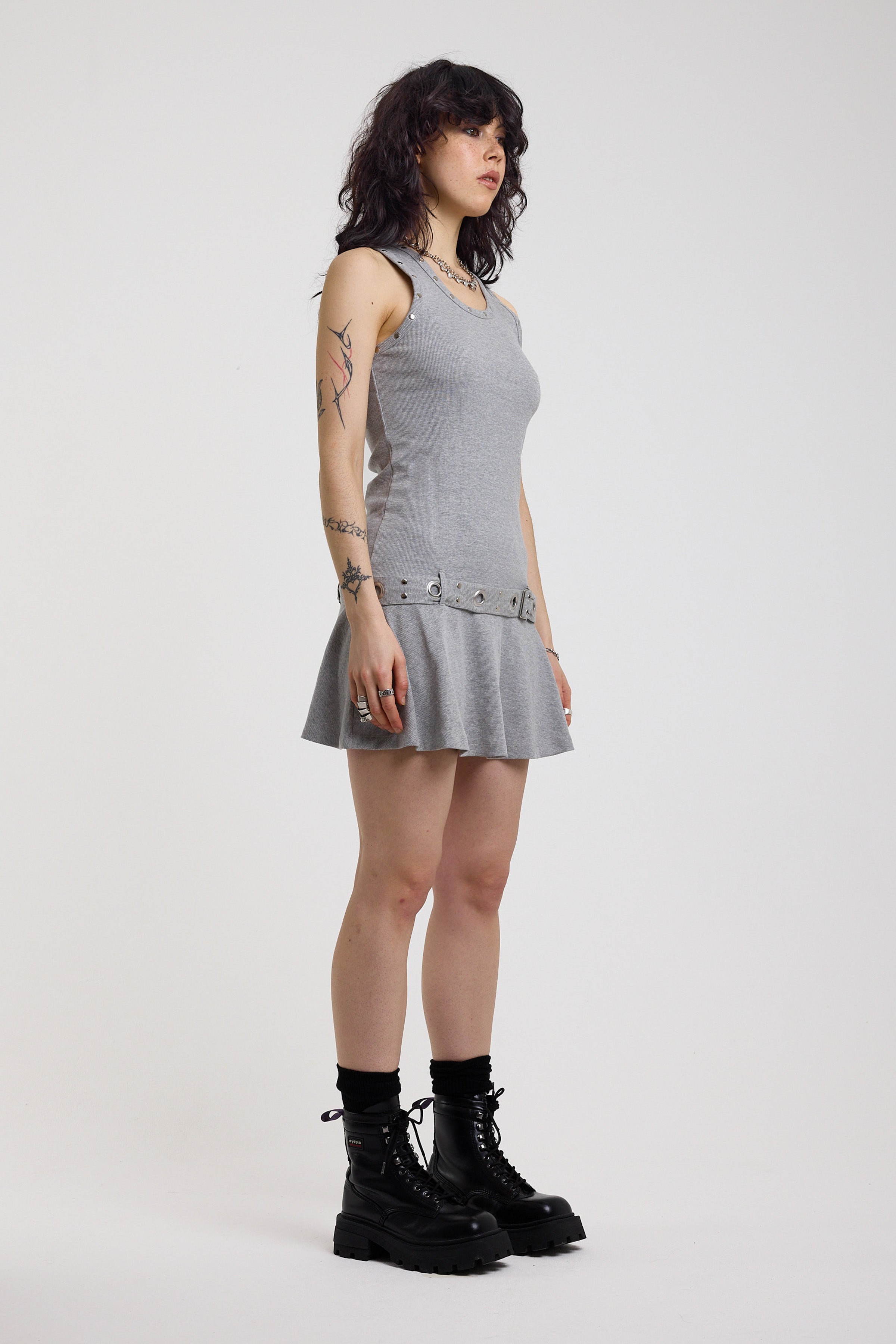 Grey mini dress with silver stud detail and eyelet detail belt, worn by model