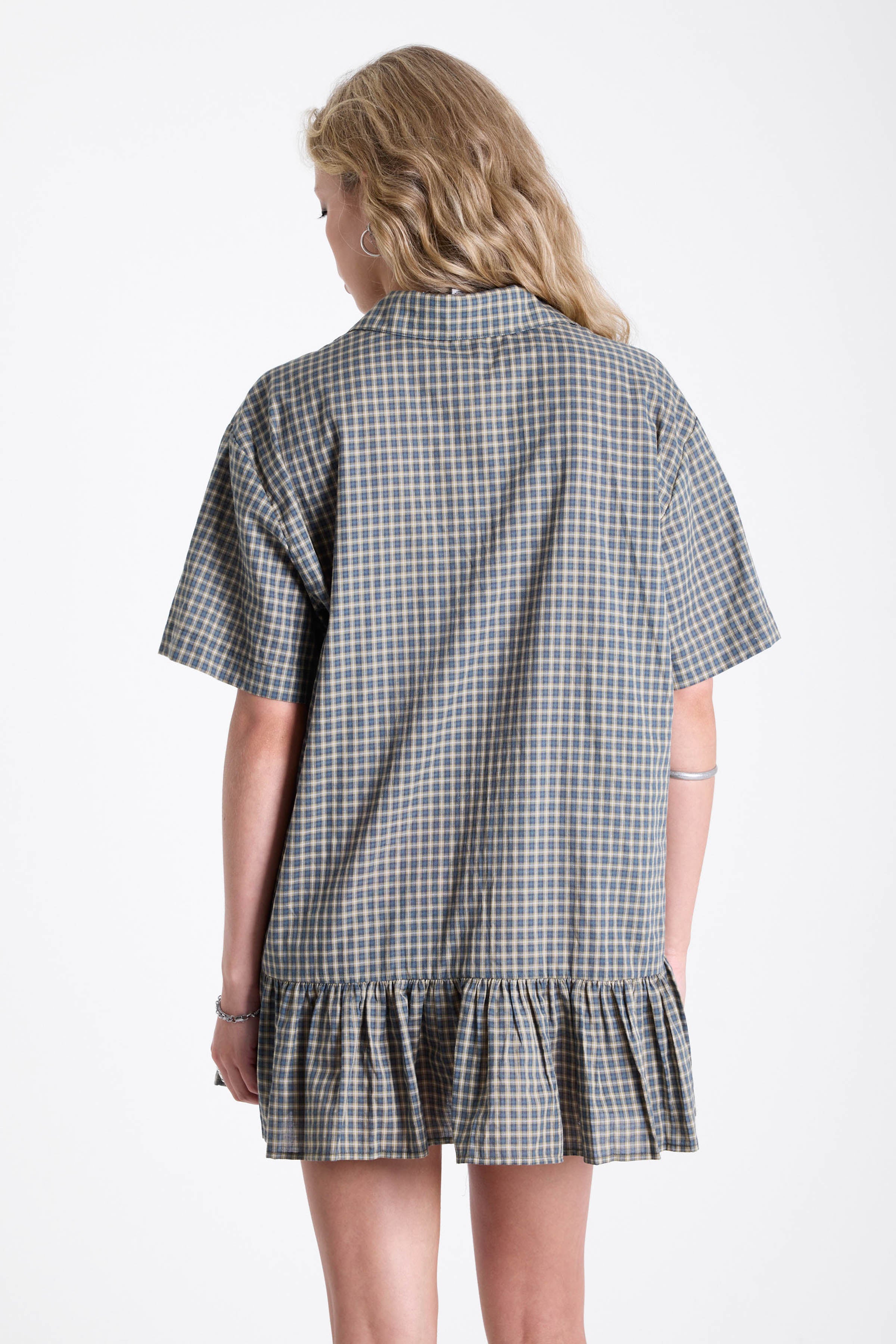 Green and yellow check shirt style mini dress with buttons, collar and peplum hem, worn by model
