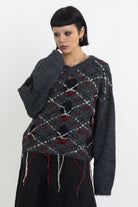 Grey argyle check knit jumper with cut outs and distressed details, worn by model
