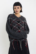 Grey argyle check knit jumper with cut outs and distressed details, worn by model