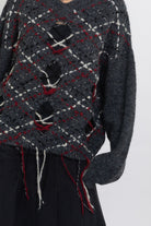 Grey argyle check knit jumper with cut outs and distressed details, worn by model