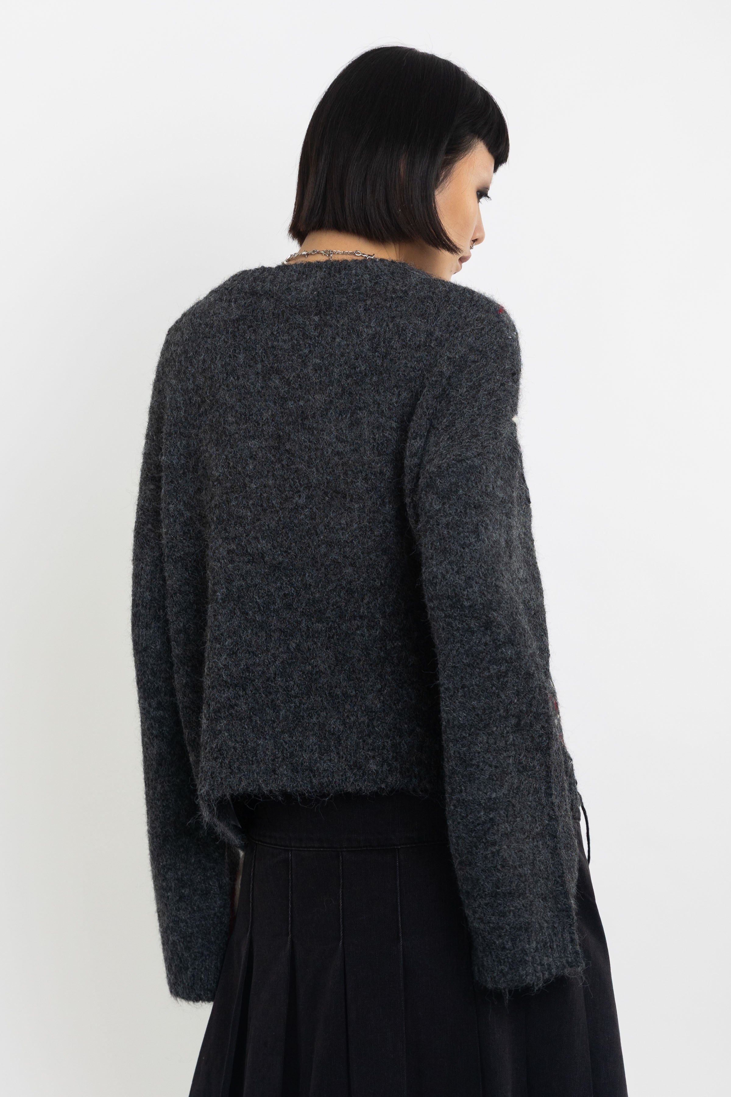 Grey argyle check knit jumper with cut outs and distressed details, worn by model