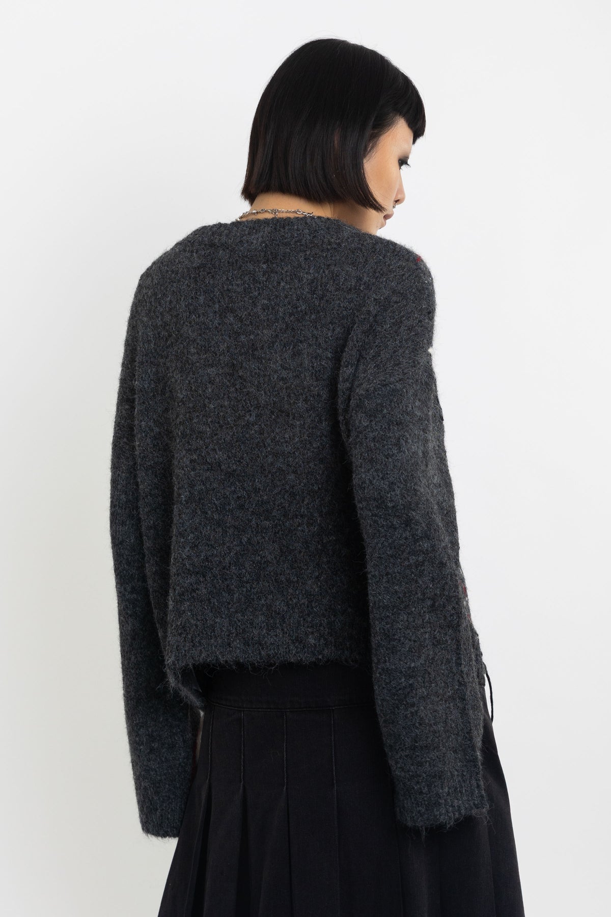 Grey argyle check knit jumper with cut outs and distressed details, worn by model