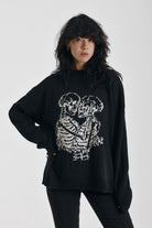 Black oversized knit jumper with skeleton graphic print, worn by model