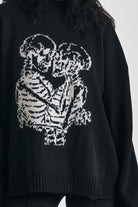 Black oversized knit jumper with skeleton graphic print, worn by model