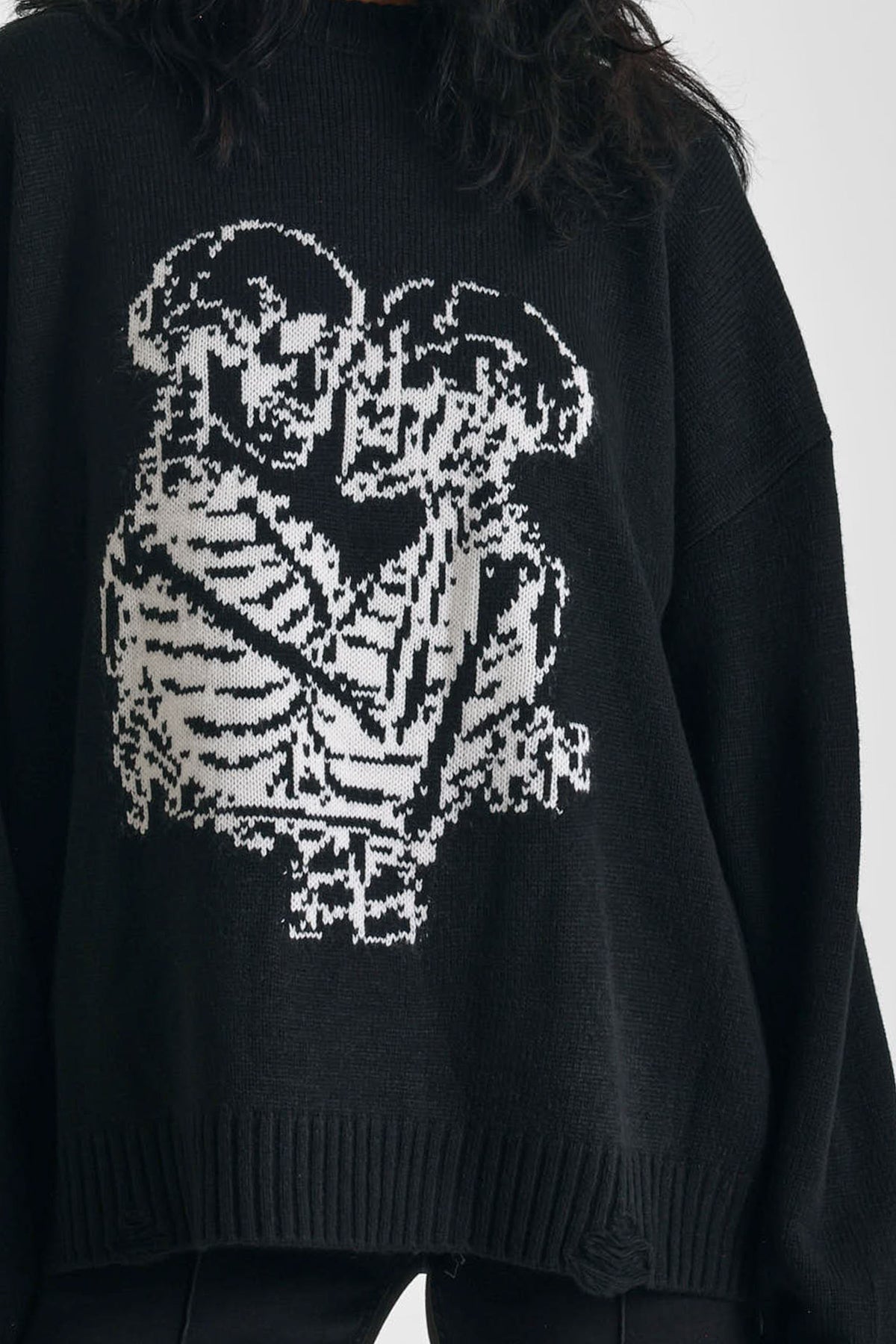 Black oversized knit jumper with skeleton graphic print, worn by model
