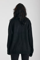 Black oversized knit jumper with skeleton graphic print, worn by model