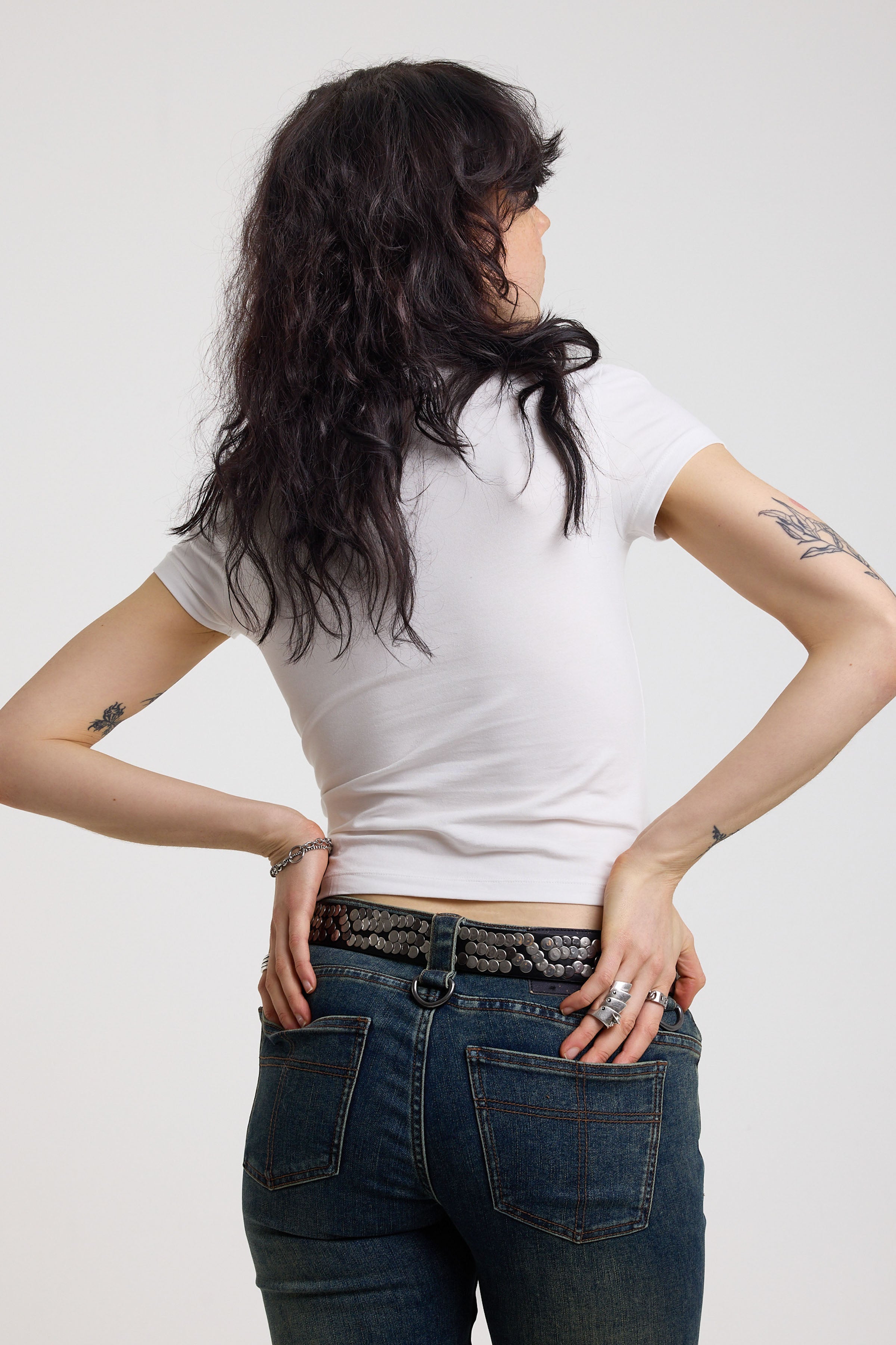 Back of white shrunken baby t-shirt with spiked lamb graphic print, worn by a model