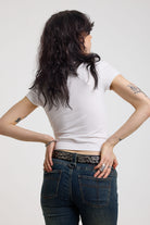 Back of white shrunken baby t-shirt with spiked lamb graphic print, worn by a model