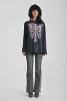 Washed black slouchy fit long sleeve t-shirt with skeleton ribcage burnout graphic, worn by model