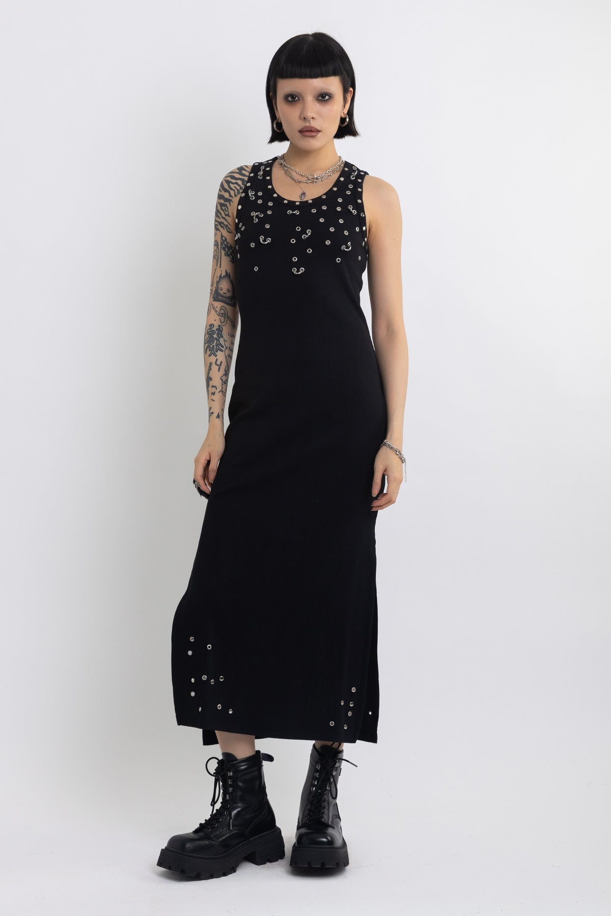 Black midi dress with silver eyelet and piercing hardware,worn by model