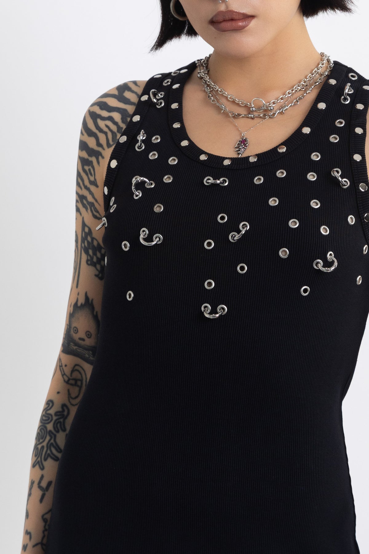 Black midi dress with silver eyelet and piercing hardware,worn by model
