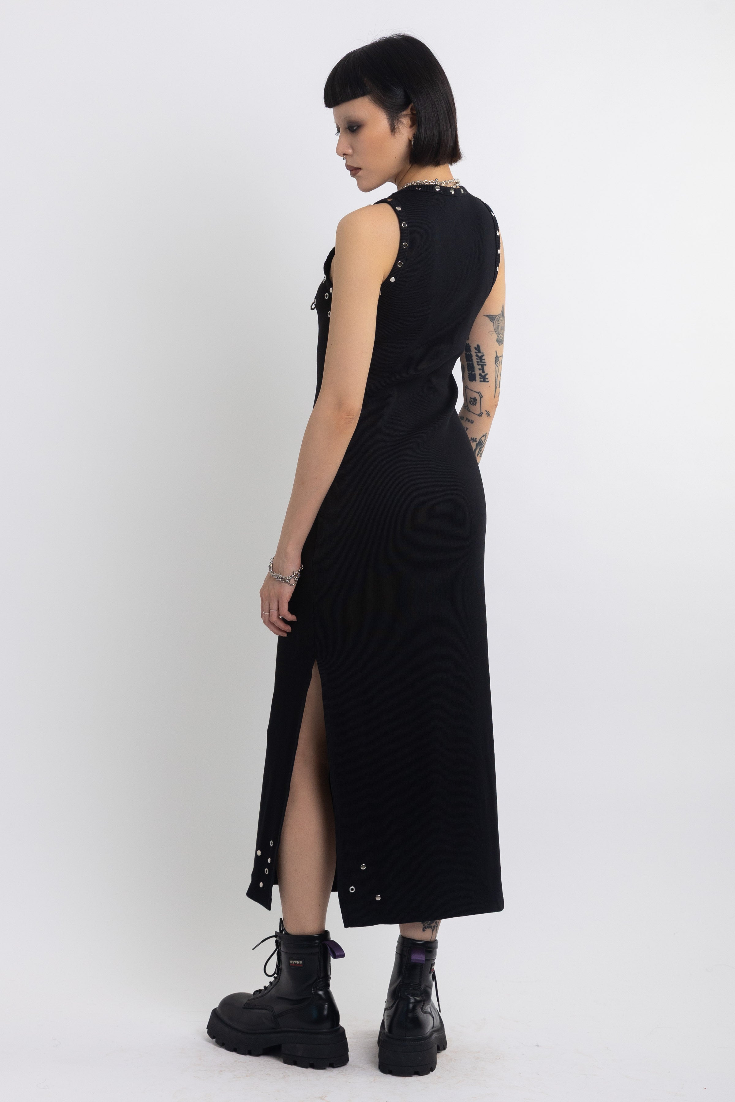 Black midi dress with silver eyelet and piercing hardware,worn by model
