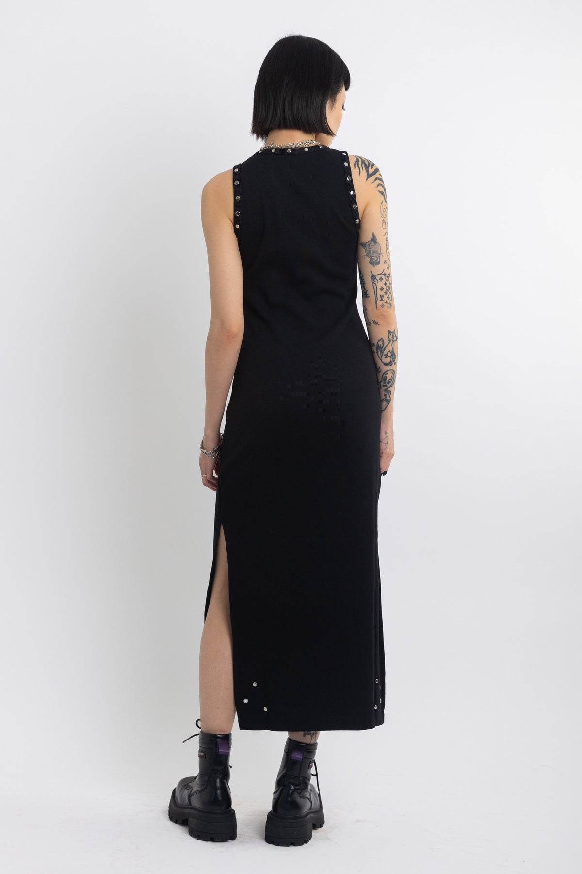 Black midi dress with silver eyelet and piercing hardware,worn by model