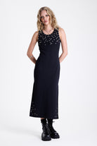 Black bodycon maxi dress with silver stud and piercing detail, worn by model
