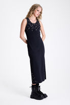 Black bodycon maxi dress with silver stud and piercing detail, worn by model
