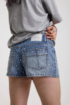 Light wash denim hotpants with all over hot fix silver studs, worn by model