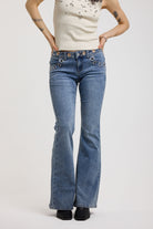 Blue flare bootcut jeans with eyelet and rivet cut out detail, worn by model