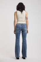 Back image of Blue flare bootcut jeans with eyelet cut out detail, worn by model